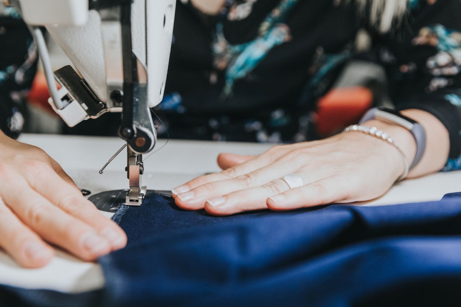 Een studente uit de bachelor modetechnologie aan het werk met een naaimachine.