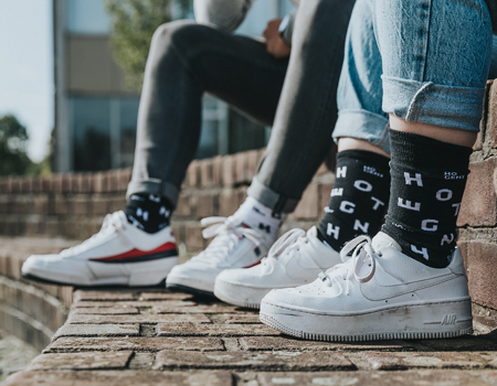 Studenten voedingstechnologie op met HOGENT-sokken tijdens een bezoek aan een voedingsbedrijf.