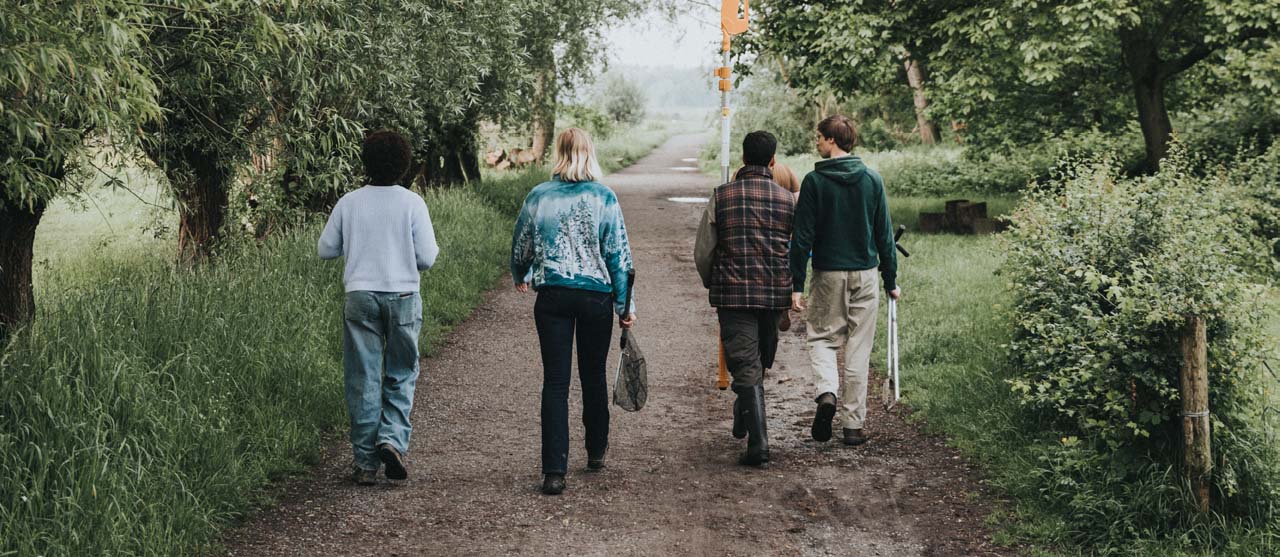 Vier studenten agro-ecologie op excursie in een bosgebied.