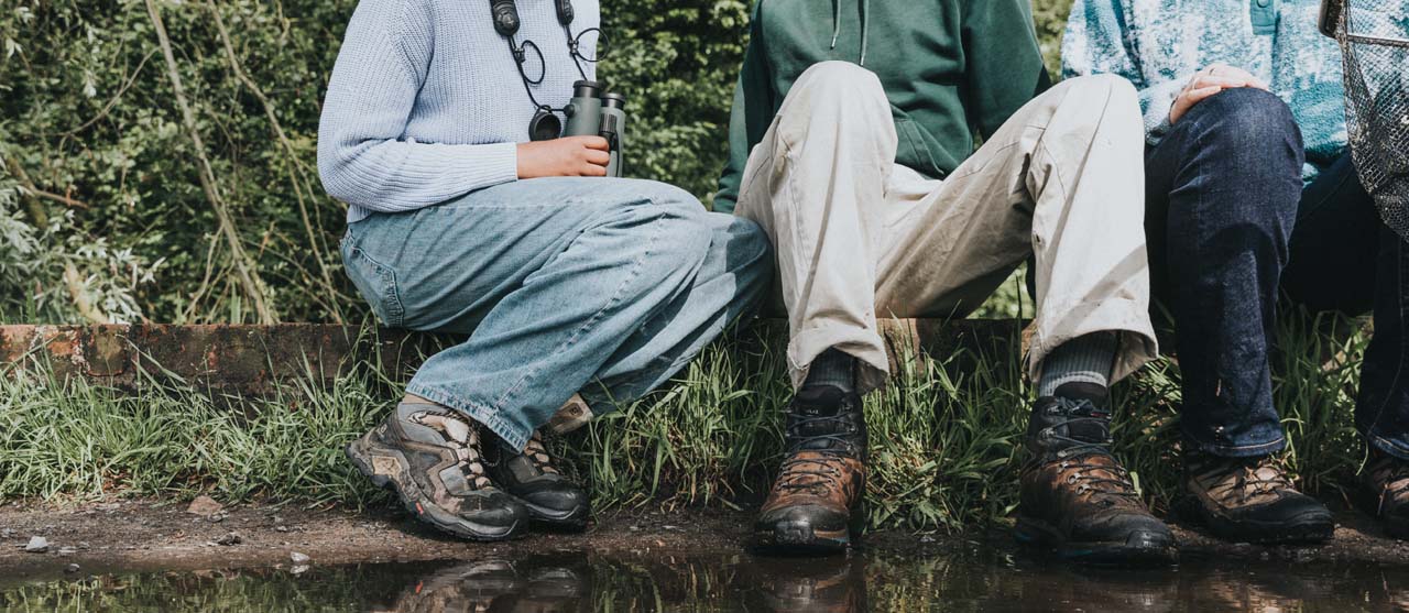 Drie studenten agro-ecologie op zoek naar de aanwezige dieren en insecten in een moerassig gebied.