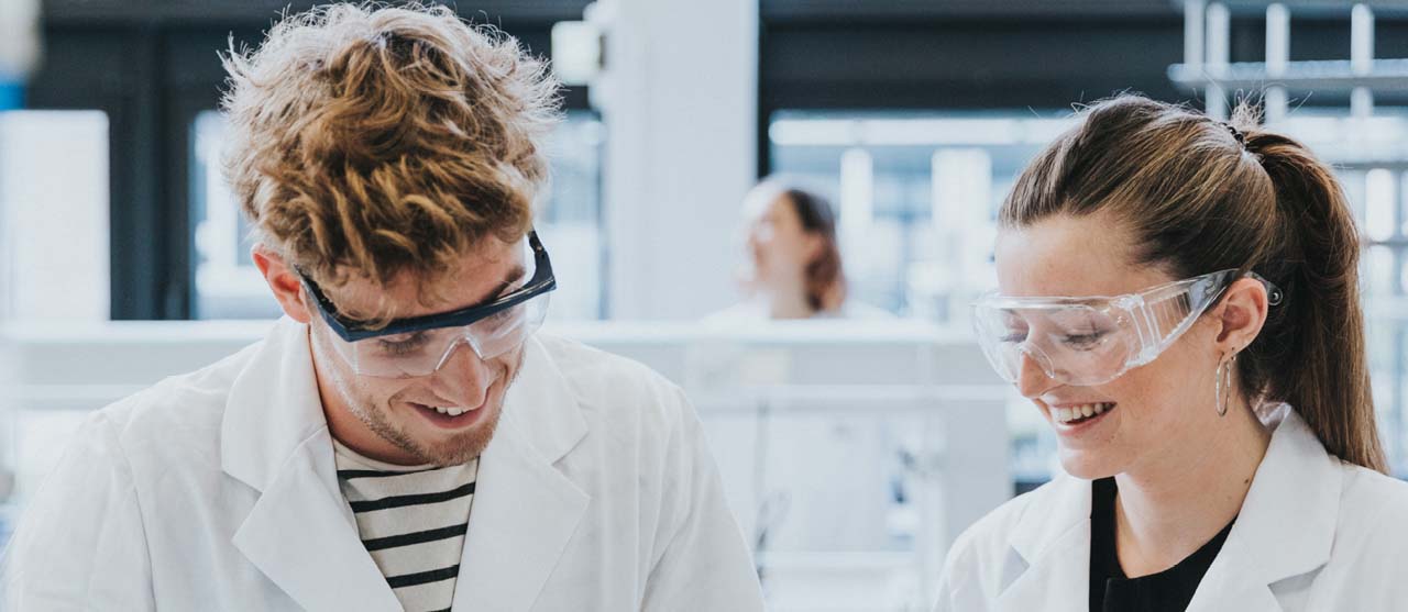  Studenten voedingstechnologie met labojas en veiligheidsbril in het laboratorium van HOGENT.