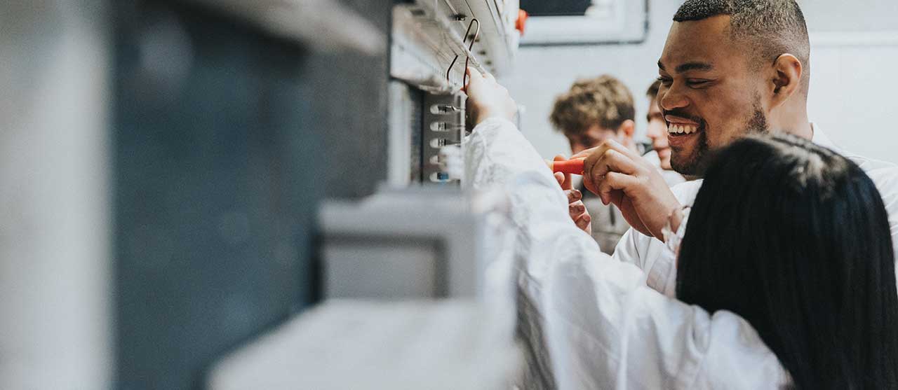 Twee studenten uit de graduaatsopleiding elektromechanische systemen aan HOGENT werken samen aan een elektromechanisch systeem.
