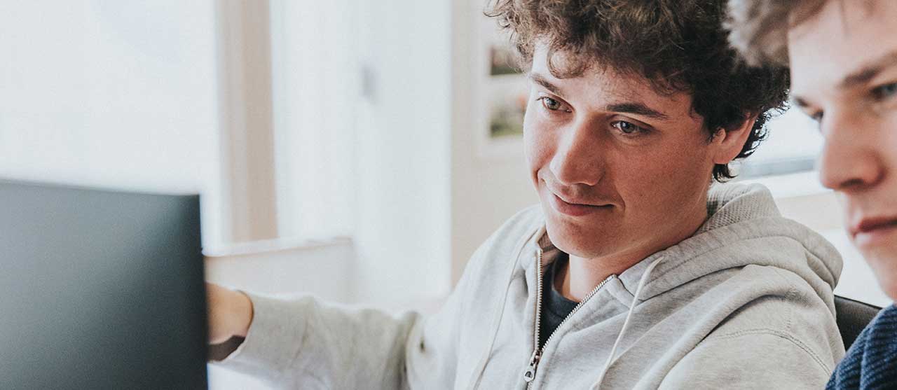 Twee studenten uit de graduaatsopleiding bouwkundig tekenen aan HOGENT kijken samen op een computerscherm.