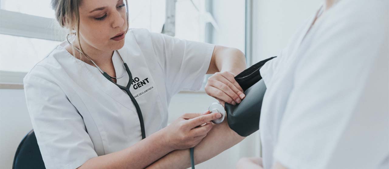 Een studente uit de opleiding basisverpleegkunde meet de hartslag van een medestudent.