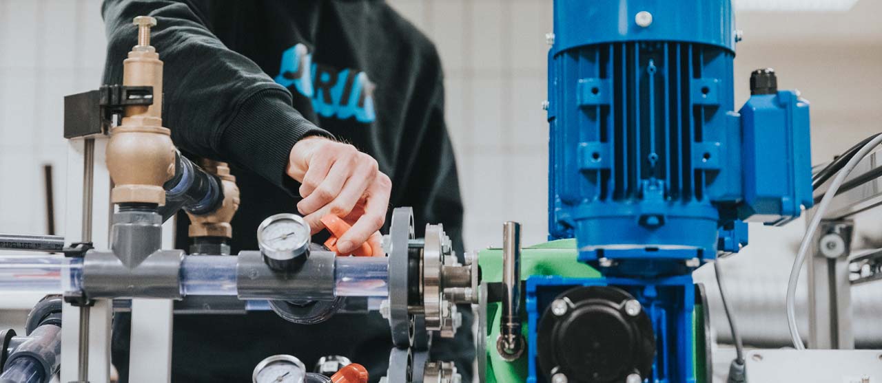 Een student elektromechanica van HOGENT werkt aan een elektromechanisch systeem in een praktijkles