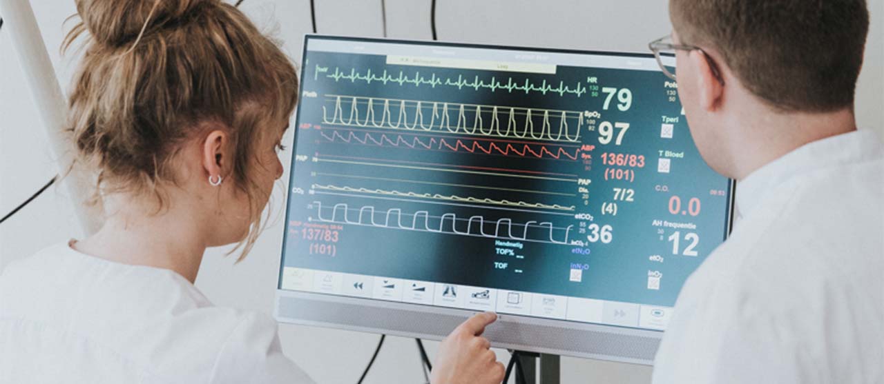 Twee studenten uit de bachelor medische technologie van HOGENT analyseren data op een patiëntmonitor.