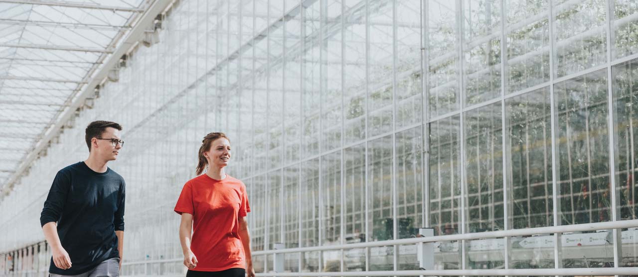 Een student milieu- en duurzaamheidsmanagement bezoekt een tuinbouwbedrijf voor het project 'duurzaamheidscoördinator'.