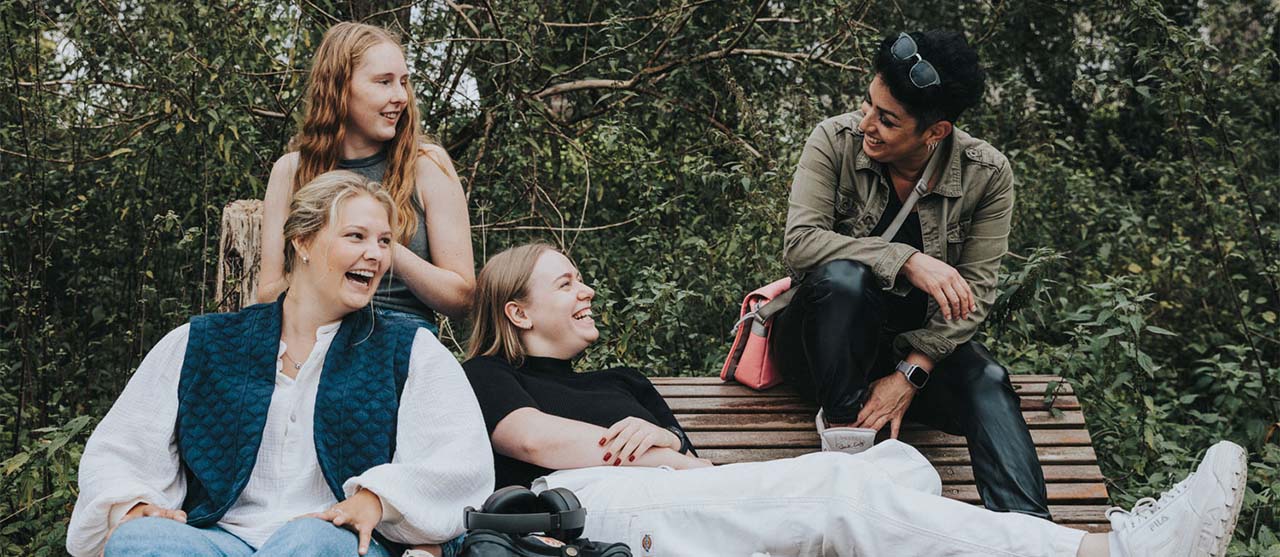 Vier lachende studenten orthopedagogie op een bank op de campus van HOGENT.