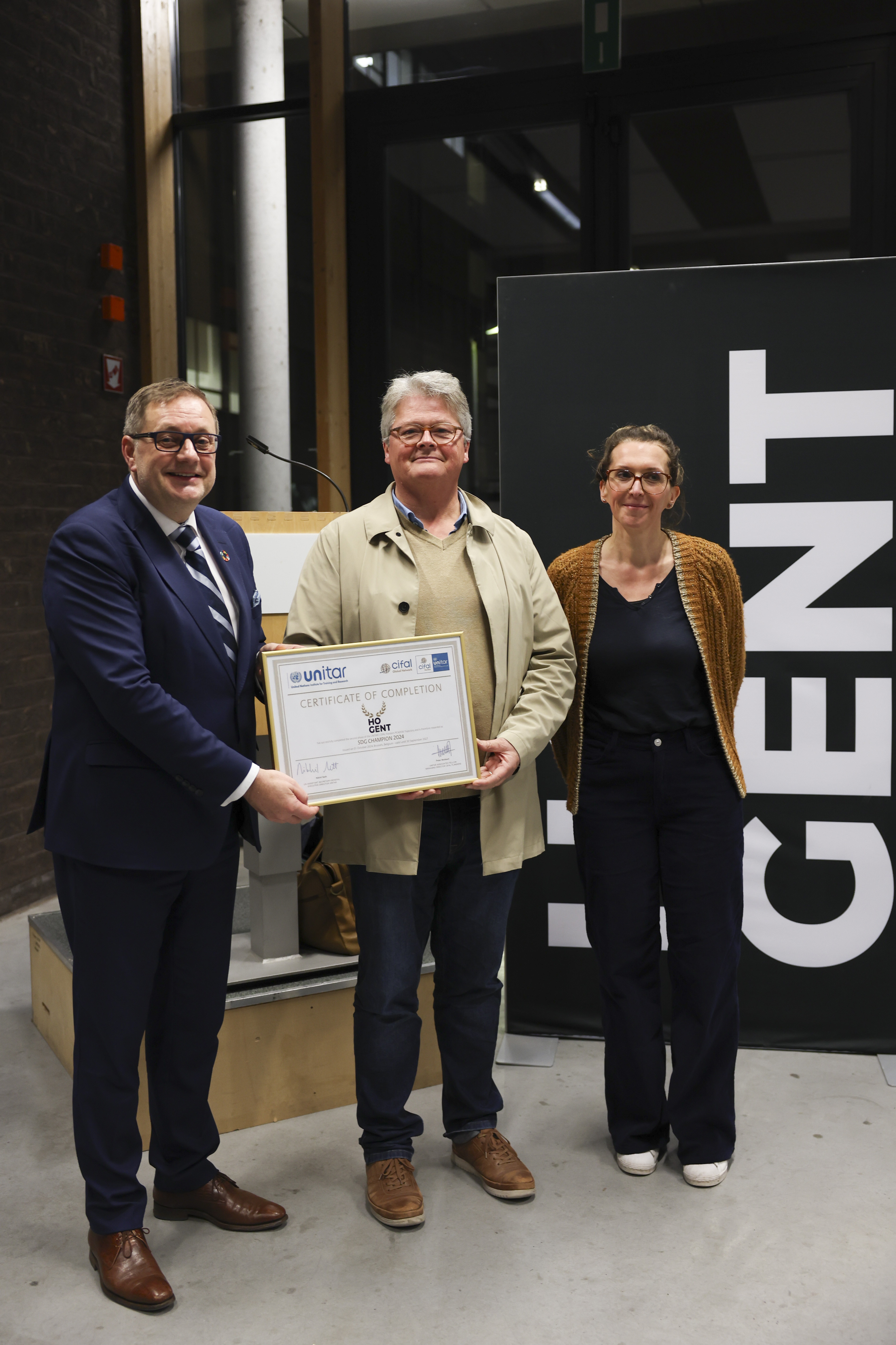 Koen Goethals, algemeen directeur HOGENT en Karen Van Bastelaere, duurzaamheidscoördinator, ontvingen het certificaat van SDG Champion uit handen van Peter Wollaert, directeur CIFAL, die het duurzaamheidstraject mee begeleidde.